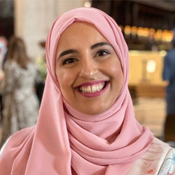 A portrait of Dr Shehla Imtiaz-Umer smiling wearing a light pink headscarf.