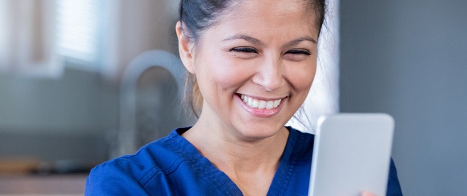 A woman smiling at a mobile phone