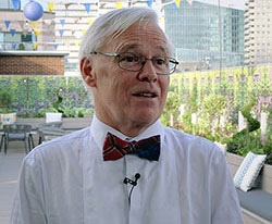 Headshot of Sir Sam Everington, wearing white shirt and red bowtie