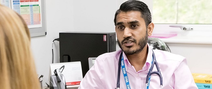 A doctor talking to a patient in a consultation room