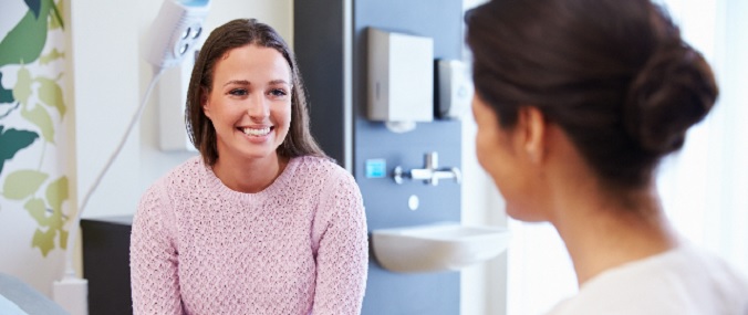 A patient smiling at their doctor in a consultation room