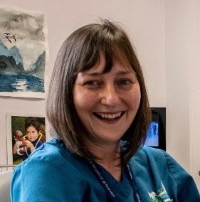 An image of Dr Rowena Christmas smiling in her general practice office.