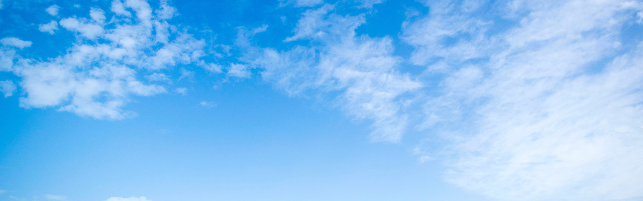 A bright blue sky with a few scattered white clouds