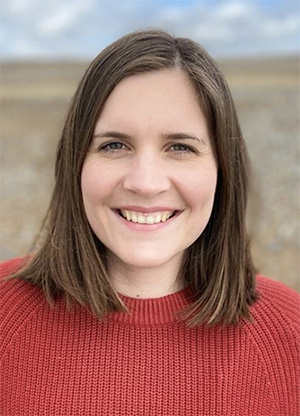 An image of Dr Tamsin Ellis outdoors wearing a red jumper.