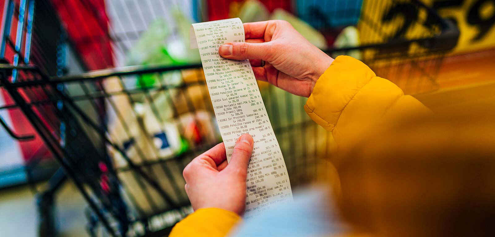 Hands holding a long receipt of bought items