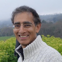 Side profile headshot from the shoulders up of Dr Amar Rughani smiling