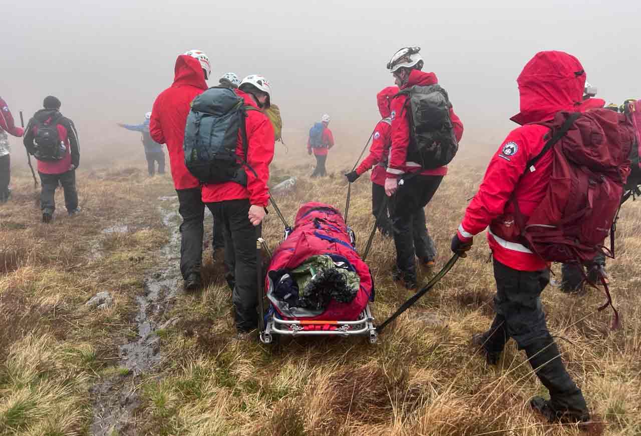 Image of various individuals carrying out rescue mission on mountain