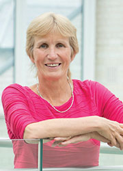 A small card image of Dr Anne Connolly wearing a bright pink top.