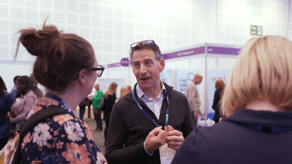 Smiling man speaking with female colleagues