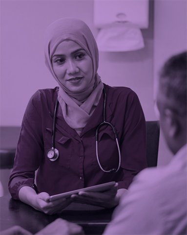 A purple-tinted photograph of a friendly GP wearing a headscarf. 