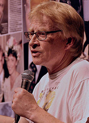 Phil Hammond speaking into a microphone