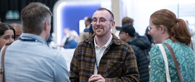 People talking and smiling at an event.