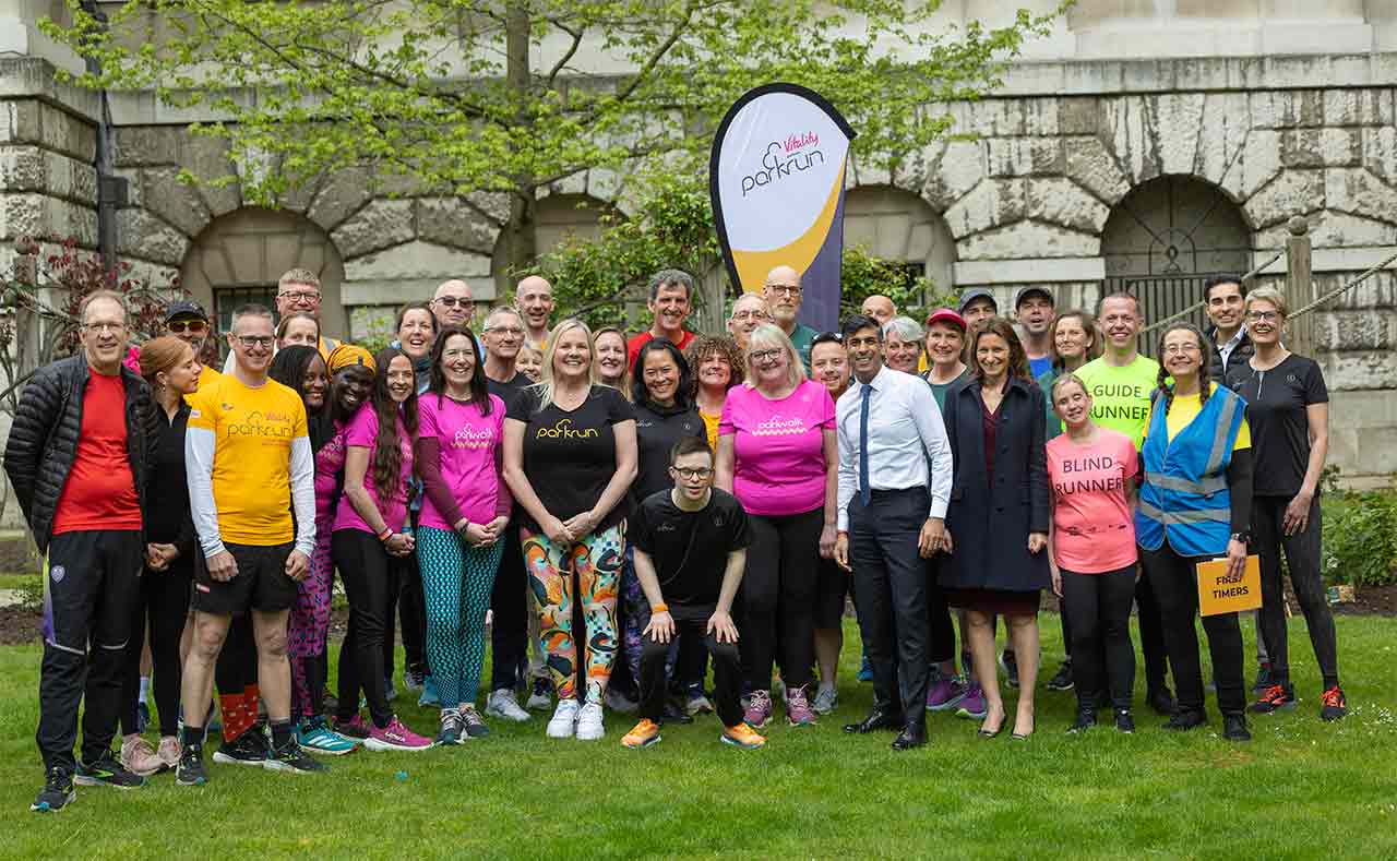 A group of parkrun representatives stand in the gardens of 10 Downing Street.  