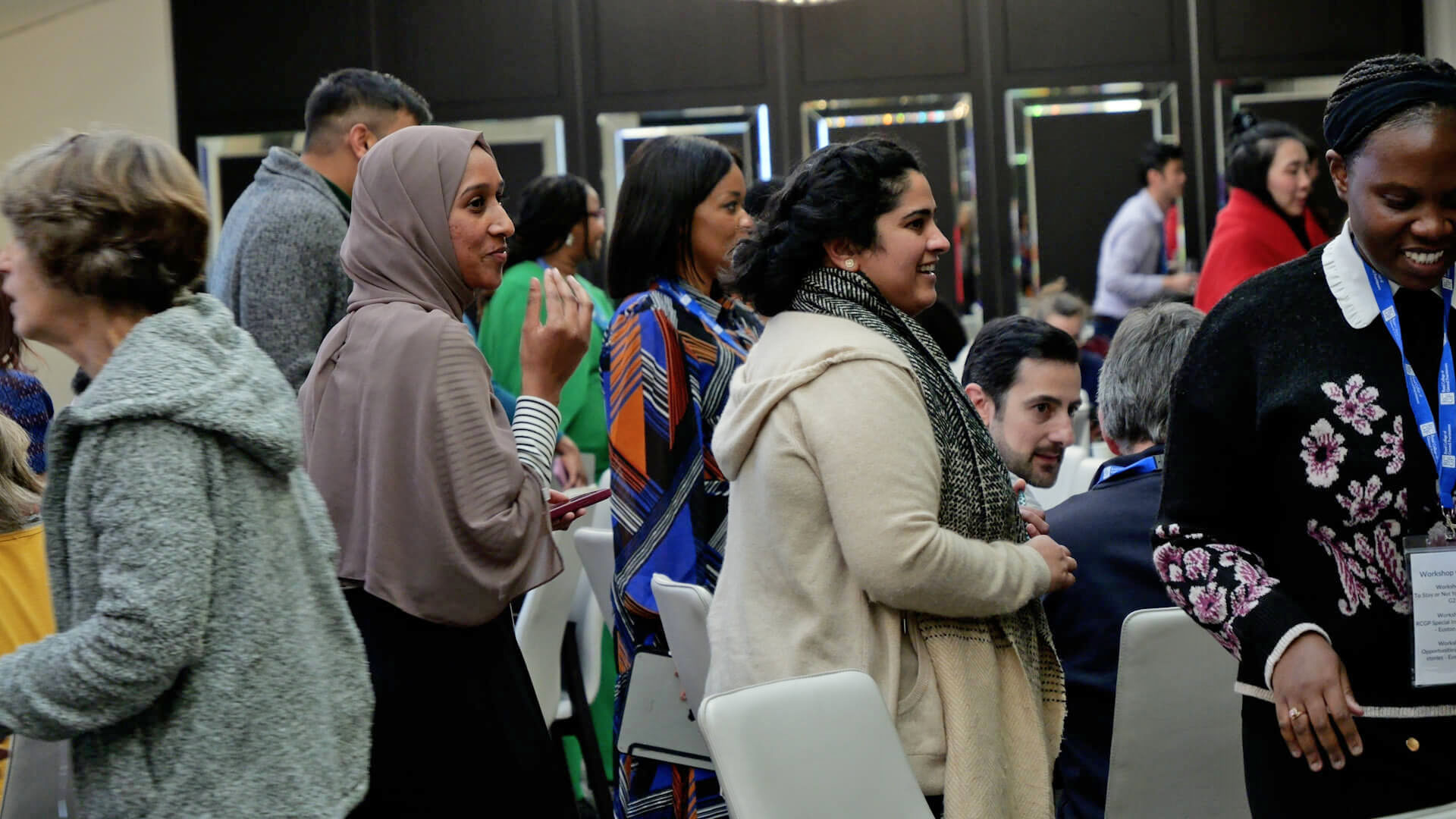 A group of people stood talking at a conference.