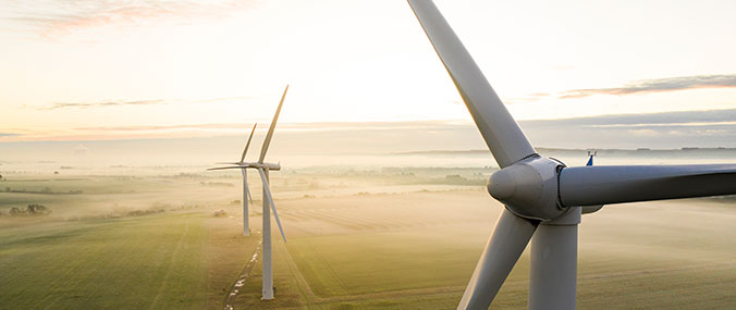 Photo of a field with three wind turbines standing in a row