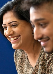 Two people, side-by-side, smiling down at something off-frame