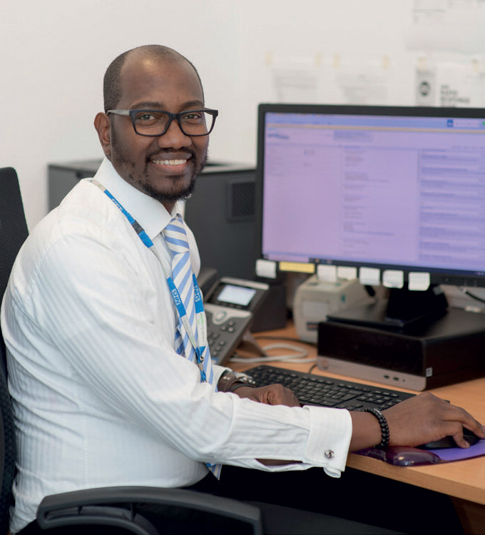 Uwa Ima Edomwonyi sitting at a desk with a computer