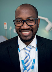 A headshot of Dr Uwa Ima-Edomwonyi wearing a suit. 